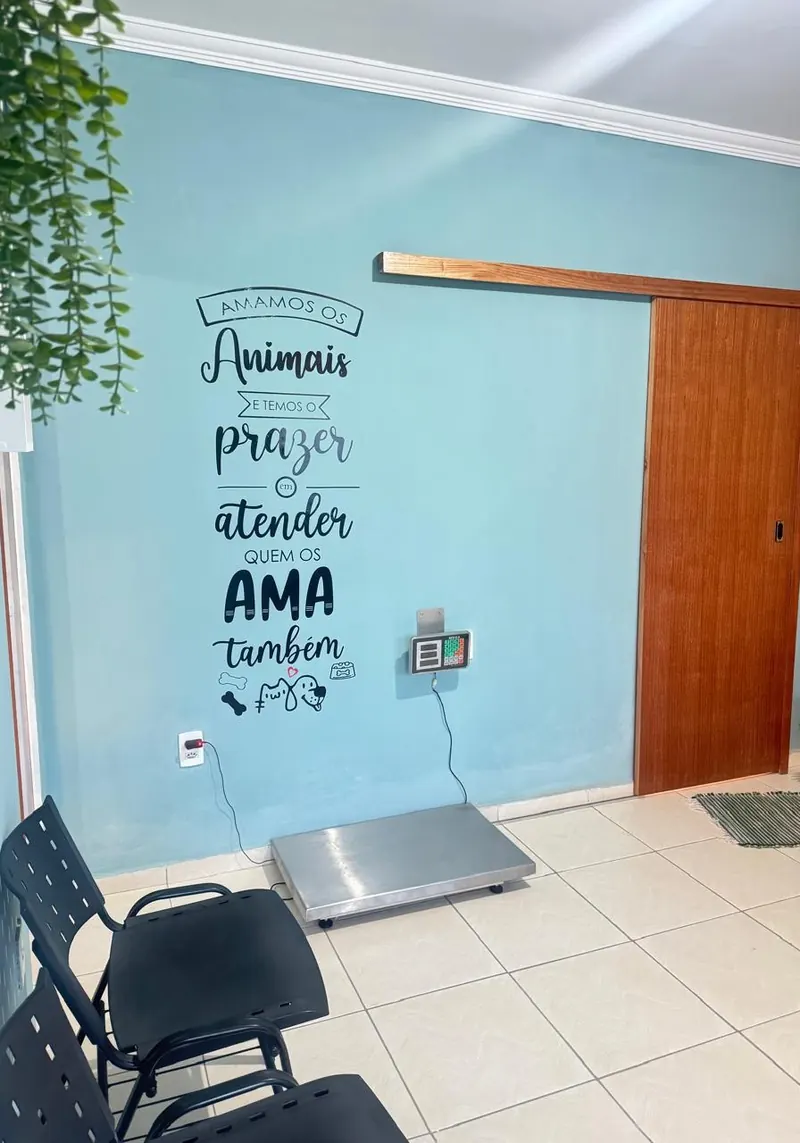 Sala de espera com cadeiras, balança e a frase Amamos os animais e temos o prazer de atender quem os ama também escrita na parede